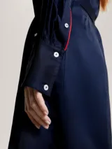 Vestido corto tipo camisa color azul marino, con cuello camisero, cierre frontal con botones y cinturón de lazo.