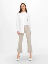 Pantalón tipo calza color beige, de corte flare y tiro alto.