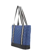 Cartera tipo shopper azul con diseño capitoneado y base negra. Tiene correas bitono, cierre de nylon con tirador textil, logo metálico, bolsillos interiores y compartimento acolchado para laptop.