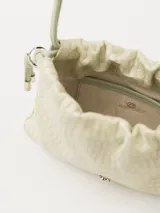 Mini bolso tipo bombonera color verde claro con textura y cordón ajustable.