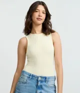 Body básico color amarillo claro, de ribana de poliamida con superficie acanalada. Prenda sin mangas, con cuello halter y cierre en la entrepierna.