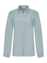 Camisa celeste de lino orgánico, de manga larga con puños abotonados, cuello camisero, cierre frontal con botones y bolsillo de parche en el pecho.