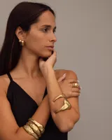 Aros pequeños de bronce con forma irregular y acabado liso, estilo huggie o argolla gruesa.