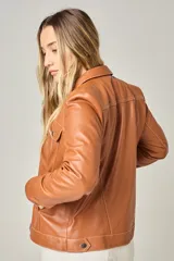 Campera tipo jeanera de cuero color peltre, con cuello clásico, cierre frontal con botones metálicos y dos bolsillos con solapa en el pecho.