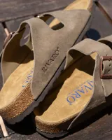 Sandalias tipo zueco de dos tiras ajustables, color beige, con hebillas metálicas color cobre. La plantilla es de corcho y látex, y la suela es de goma.