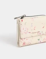 Billetera de cuerina color rosa con estampado escocés, solapa con broche y tag metálico.
