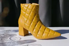 Bota corta de cuero rojo con diseño capitoneado, forro y plantilla de cuero. Taco cuadrado de 6 cm.