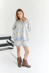 Sweater de lana color beige con diseño geométrico de rombos en tonos beige y blanco, cuello en V y corte holgado.