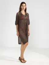 Camisa larga negra de punto calado con cuello camisero, manga tres cuartos y cierre frontal con botones.