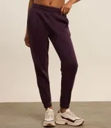 Pantalón deportivo color morado, de algodón y poliéster, con cintura elástica y bolsillos laterales.