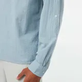 Camisa celeste de manga larga con cuello mao y cierre parcial con botones.