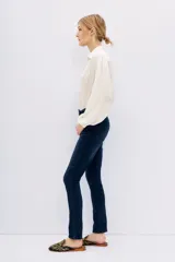 Pantalón de jean azul oscuro, corte slim, tiro alto y bolsillos delanteros y traseros.