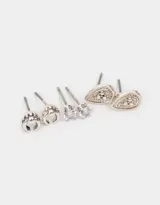 Set de tres pares de aros pasantes plateados con diferentes diseños: un par con forma de medialuna con strass, un par con circonita engarzada y un par con forma de lágrima con strass.