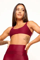 Top deportivo reversible color bordó, con diseño slim, tirantes finos y espalda descubierta. Un lado tiene acabado brillante y el otro textura 3D tipo colmena.
