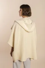 Ruana color crudo de lana fina sin teñir, con capucha, bolsillos y terminaciones envivadas. Tiene un broche para usar cerrada. Es una prenda oversize sin forro, cómoda, versátil y fácil de combinar.