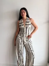 Pantalón de pierna ancha con estampado de rayas verticales negras sobre fondo crudo, confeccionado en tela slab con cintura elástica.