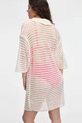 Vestido tejido calado negro con cuello camisero y manga corta.