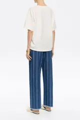 Pantalón denim azul con rayas verticales blancas, corte recto, largo tobillero y bajo desflecado.