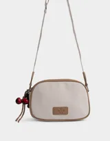 Bandolera de cuerina azul marino y beige con correa regulable azul y charm lateral decorativo. Tiene cierre superior y tag frontal con logo "The Brunch Club".