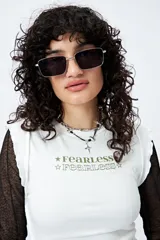 Remera negra con estampa frontal de la palabra 'Fearless' en color blanco. Corte ajustado y terminaciones con volados sutiles.