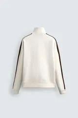 Sudadera color crudo de corte relaxed fit, con cuello alto con cremallera y mangas largas con banda marrón a contraste.