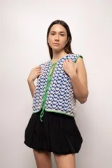 Chaleco tejido a crochet con hilado 100% algodón, color crudo con detalles en azul.