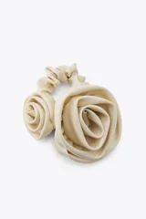 Coletero elástico color beige con dos flores grandes de tela en relieve.