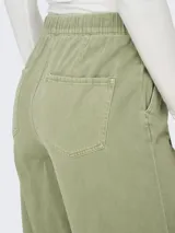 Pantalón largo verde claro de corte amplio, con cintura de tiro medio y ajuste mediante cordón.