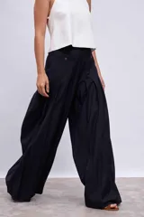 Pantalón palazzo plisado color azul marino, de tiro alto con bolsillos laterales y cierre frontal con botón.