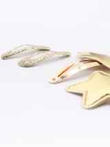 Set de cuatro hebillas para el pelo: dos doradas con forma de estrella y dos plateadas con glitter.