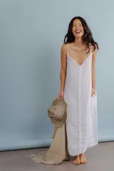 Vestido largo de lino color blanco, con breteles finos y detalle de costura o aplique vertical en el centro del frente.