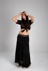 Pollera larga celeste de tela liviana, con cintura ajustable mediante cordón blanco con borlas y falda con volados en capas.