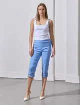 Pantalón capri blanco de gabardina elastizada con bolsillos simulados, pretina ancha, corte recto y detalle de puntilla en el ruedo.