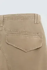 Pantalón cargo color beige, de corte relaxed fit, con bolsillos frontales, traseros con solapa y bolsillos laterales tipo parche con solapa.