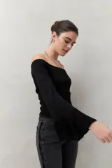 Top tejido color beige con escote off-shoulder y mangas largas acampanadas.