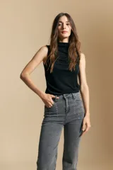 Jean de corte recto y tiro medio, color gris oscuro con efecto lavado. Presenta apliques de tachas metálicas pequeñas en la zona de los bolsillos delanteros.