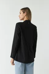 Blazer negro de algodón con bolsillos tipo cartera y cierre con botones.
