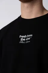 Remera color beige de corte oversize, con cuello redondo y mangas cortas. Estampa pequeña en el frente con la frase "Fresh from the vine".