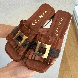 Zueco marrón de cuero vacuno con capellada fruncida y hebilla dorada.