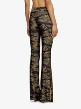 Pantalón de tiro alto con diseño cruzado en la cintura y corte acampanado, confeccionado en tela estampada de camuflaje militar en tonos verde, marrón y beige.