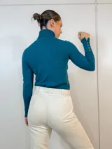 Polera azul de cuello alto, mangas largas y corte ajustado.