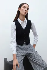Chaleco de punto negro, con escote en V y cierre frontal de botones.