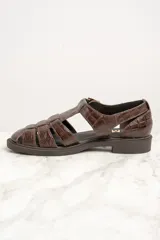 Sandalias cangrejeras de cuero marrón con textura croco, hebilla dorada y suela plana.