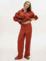 Pantalón ancho de pierna color ladrillo, confeccionado en lino, con elástico en la parte trasera de la pretina y detalle al costado tipo naval. Fit tiro alto.