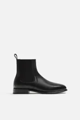 Bota Chelsea de cuero negro, con elásticos laterales, tirador trasero y suela con ligero tacón.