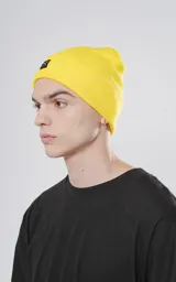 Gorro de lana amarillo tejido con poliéster y acrílico, con logo de la marca en etiqueta negra.