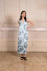 Vestido largo sin mangas con estampado batik en tonos celeste y gris, escote en V y aberturas laterales.