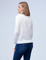 Polera de punto fino marca Nienty, color blanco, con cuello alto volcado y mangas largas con detalle de tajo en los puños.