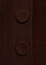 Buzo marrón de punto fino con diseño semitransparente, cuello Perkins, cierre de botones laterales y abertura lateral. Corte estándar y mangas largas.