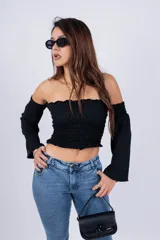 Top color beige, con escote off-shoulder con elástico y mangas largas acampanadas.